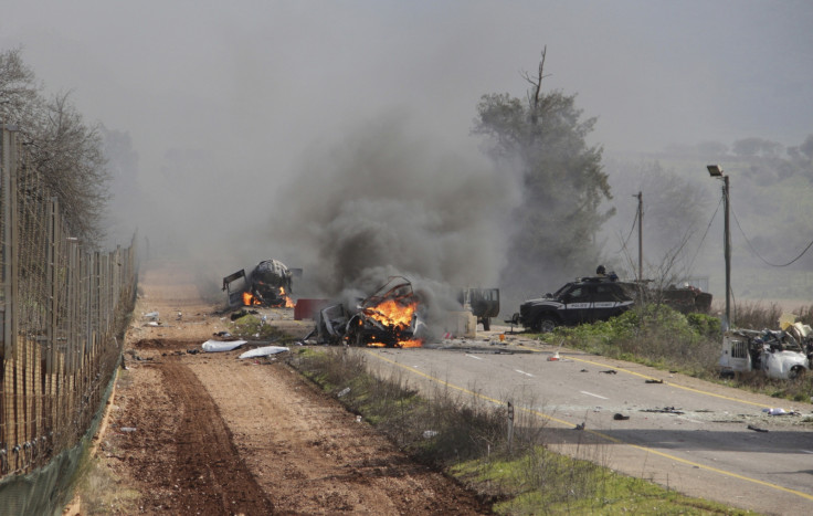 Burning vehicles are seen near the village of Ghajar on Israel's border with Lebanon
