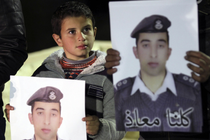 A relative holds a picture of Jordanian pilot Muath al-Kasaesbeh, who was captured by Islamic State after his plane crashed in Syria