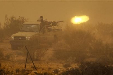 Libyan rebels fire an anti-aircraft gun at government forces during a heavy sandstorm near the village of Tiji in western Libya