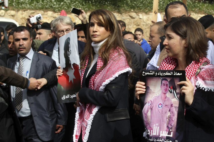 Jordan's Queen Rania (C) holds a picture of recently executed Jordanian pilot Muath al-Kasasbeh, with the words in Arabic reading