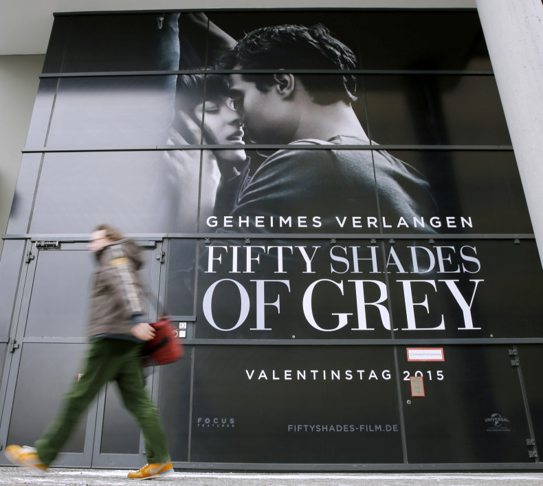 A pedestrian walks past an advertising placard for the movie 'Fifty Shades of Grey'