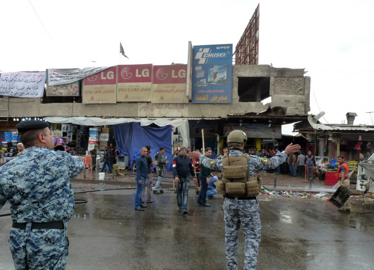 Iraqi police clear pedestrians of a street after a suicide bomber detonated explosives inside a restaurant in Baghdad al-Jadida, east of the capital,