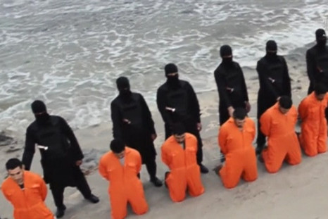 Men in orange jumpsuits purported to be Egyptian Christians held captive by the Islamic State (IS) kneel in front of armed men along a beach said to be near Tripoli