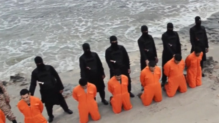 Men in orange jumpsuits purported to be Egyptian Christians held captive by the Islamic State (IS) kneel in front of armed men along a beach said to be near Tripoli