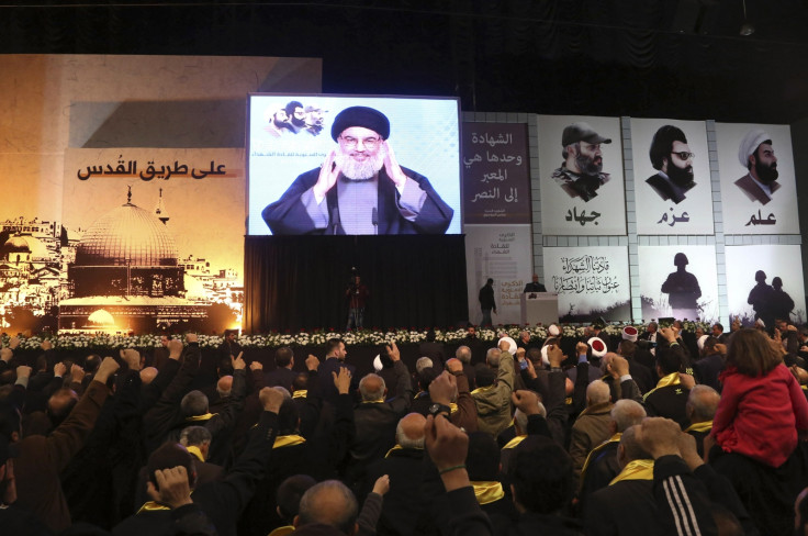 Lebanon's Hezbollah leader Sayyed Hassan Nasrallah greets his supporters through a giant screen during a rally commemorating the annual Hezbollah Martyrs' Leader Day in Beirut's southern suburbs February 16, 2015