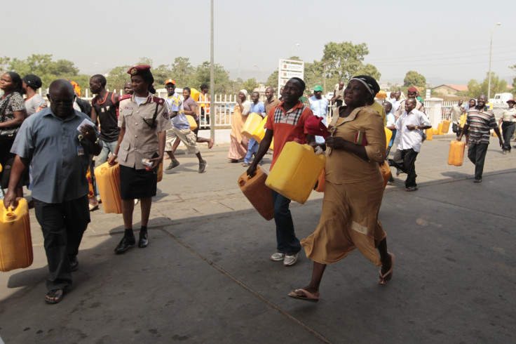 People run toward kerosene cooking fuel pumps during the launch of the