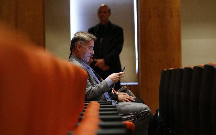 Brazilian tycoon Eike Batista checks his mobile phone before his court hearing in Rio de Janeiro November 18, 2014.
