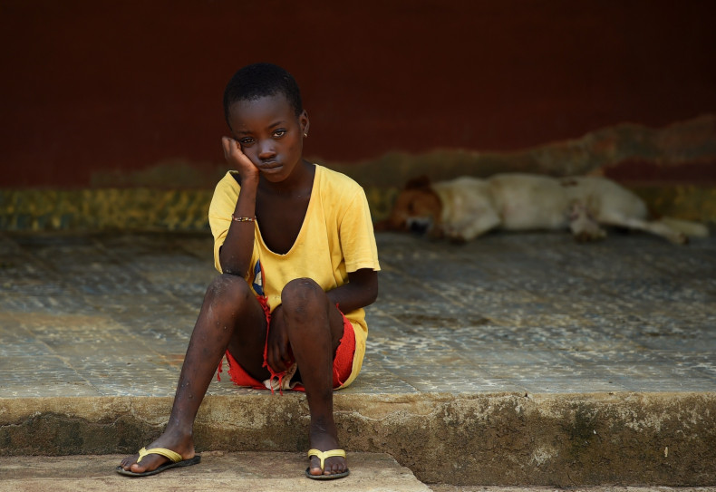 A child under quarantine sits outside a care center in Lokomasama, in the Port Loko province which has been severelly hit by the Ebola.