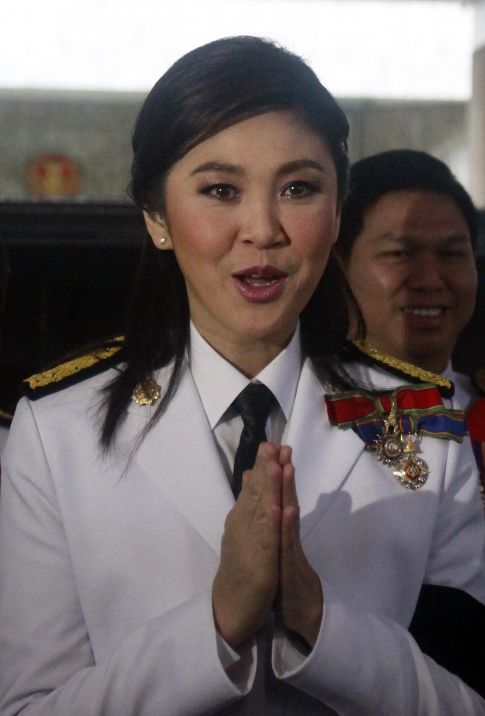 Prime Minister elect Yingluck Shinawatra of the Puea Thai Party gestures to media as she arrives at the parliament before the inauguration ceremony of the National Legislative Assembly in Bangkok