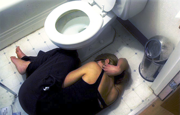 Woman lying bathroom floor pain