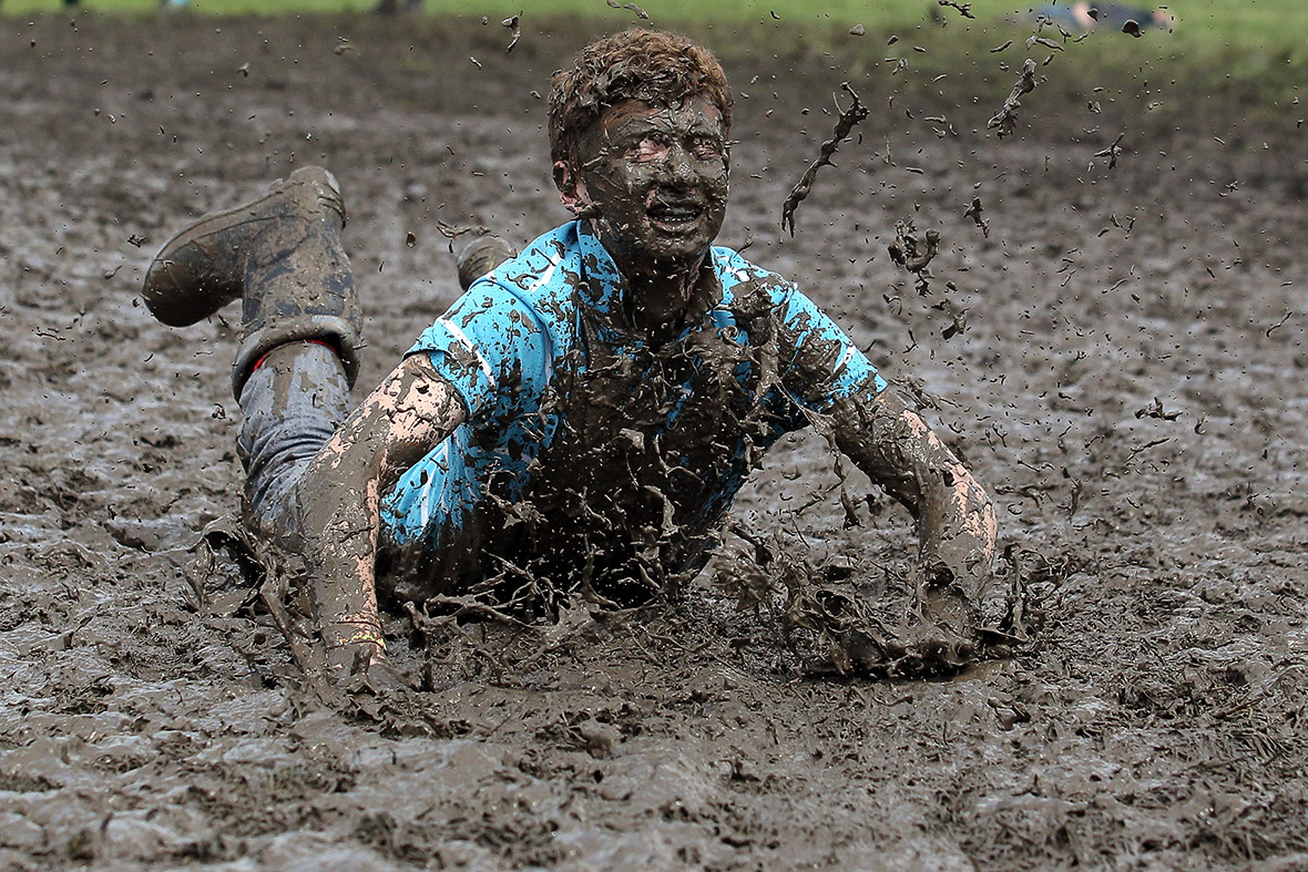 A festival-goer jumps in a mud puddle on the second day of the 2013 Glaston...