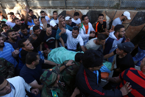 Palestinians carry the body of