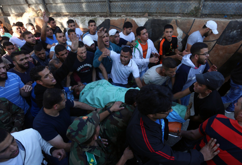 Palestinians carry the body of