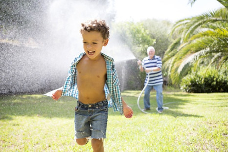 Child playing in sprinklers