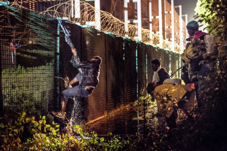 A migrant climbs a security