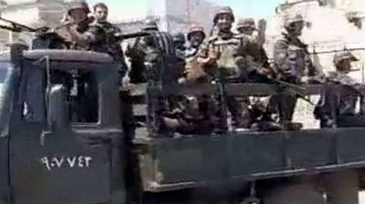 Army trucks carrying soldiers enter into city