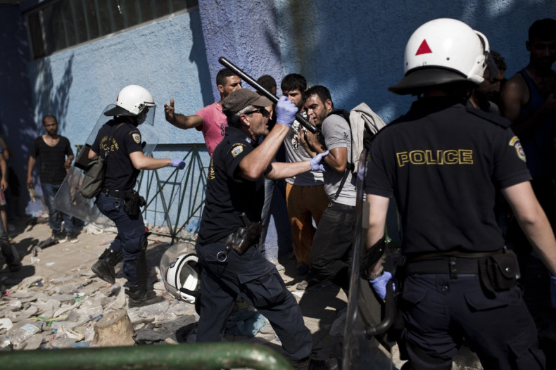 Policemen try to disperse migrants