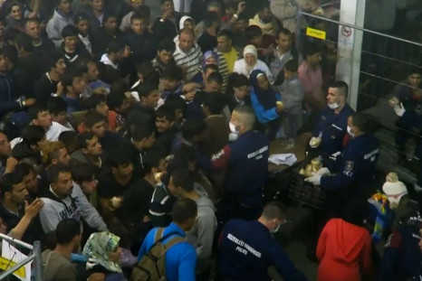 Hungarian police throws food at migrants