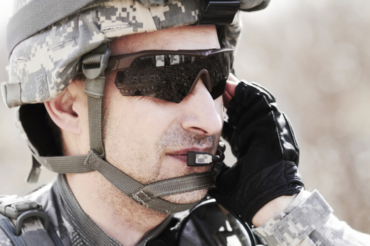 A soldier talking on a radio headset