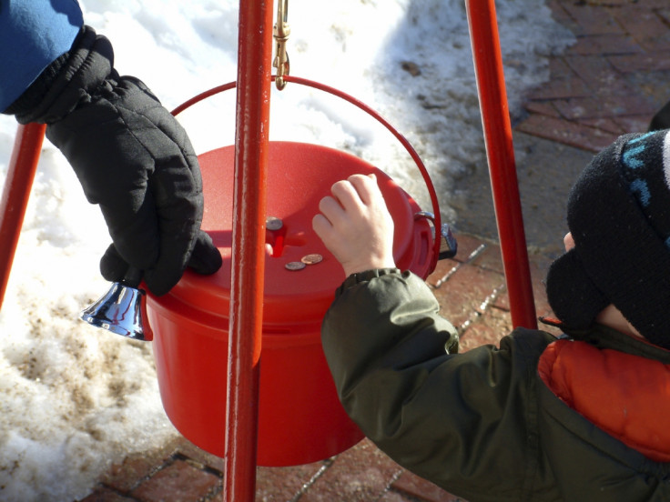 Young child puts coins in charity box