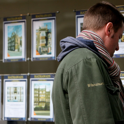 Man looking at estate agent window