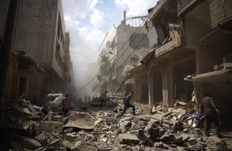 Syrians walk amid the rubble