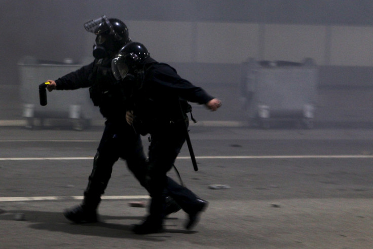 A policeman helps an injured colleague during clashes with protesters in Kosovo's capital Pristina October 12, 2015.