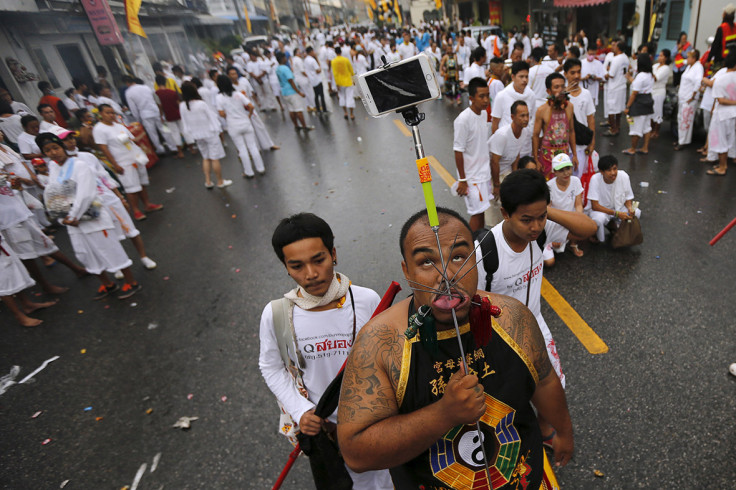 Thailand vegetarian festival: Bizarre facial piercings include guns,  umbrellas and tricycles [Graphic images]