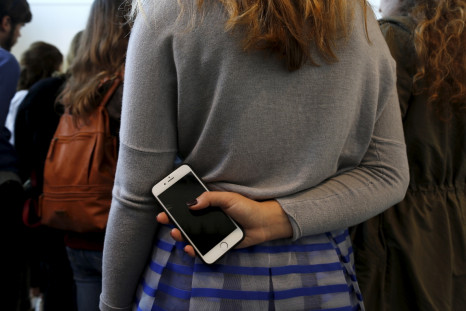 woman holding smartphone behind her back