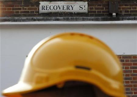 A construction worker walks past a street sign in south London