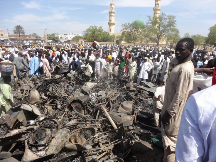 Residents look at a burnt motorcycles