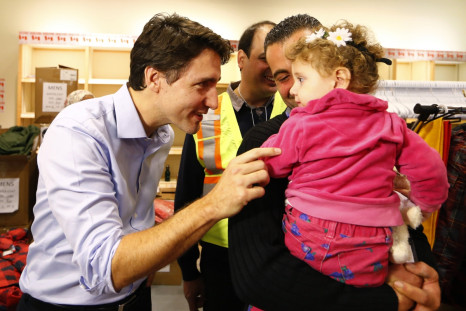 Syrian refugees are greeted by Justin Trudeau