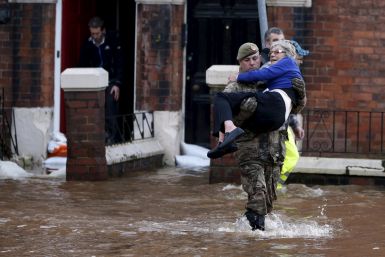 soldier carries woman out of flooded house
