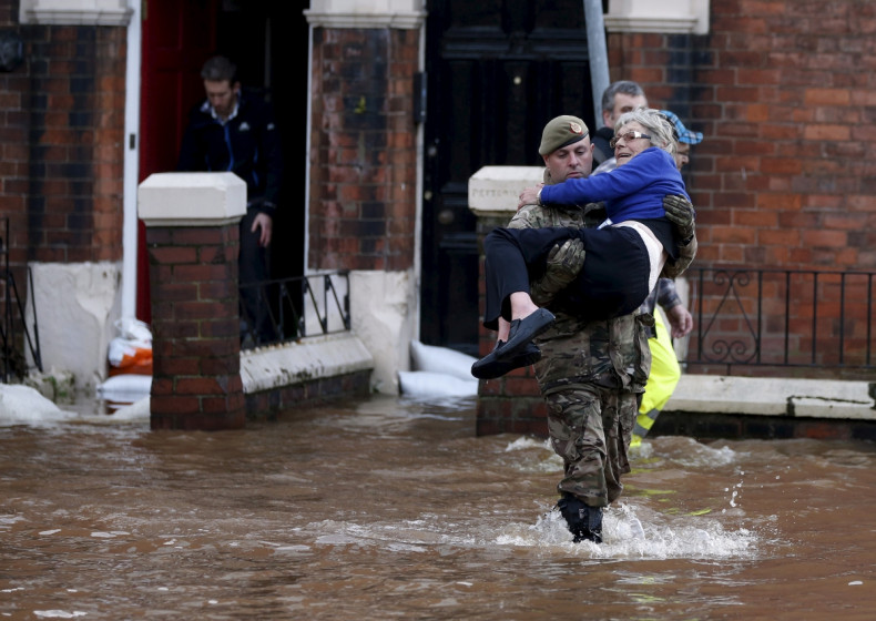 soldier carries woman out of flooded house