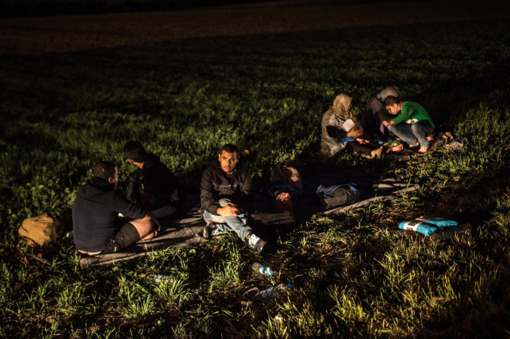 Migrants rest by the road