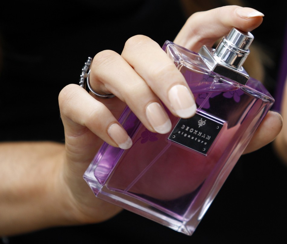 A woman sprays perfume from a bottle of Victoria Beckham039s 039Signature039 fragrance at Harvey Nichols in Manchester