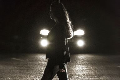 A woman walks past a car