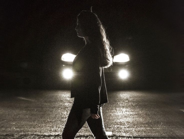 A woman walks past a car