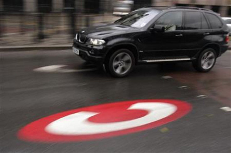 A large vehicle drives past a symbol for the Congestion Charge in London