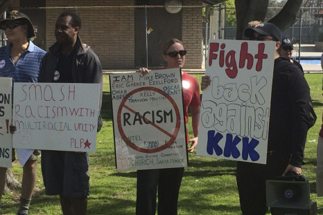 Counter protesters hold placards near a planned Klu Klux Klan rally