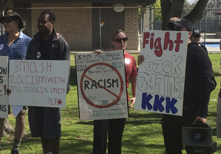 Counter protesters hold placards near a planned Klu Klux Klan rally