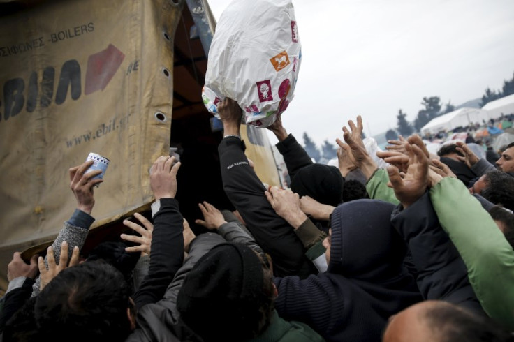 Refugees rush a food truck