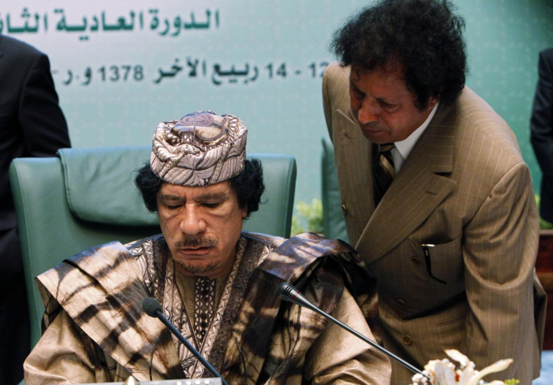 Muammar Gaddafi (L) listens to Ahmad Gaddaf al-Dam