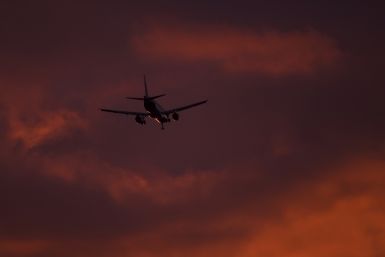 A passenger aircraft makes its landing approach at dusk