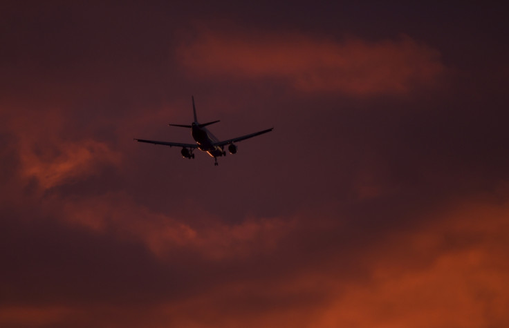 A passenger aircraft makes its landing approach at dusk