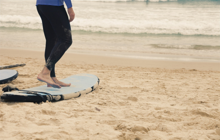 A surfer prepares on the beach