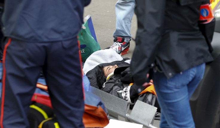 Rescue workers give aid to a woman who was struck by a car that ran through a road block in the Brussels district of Molenbeek