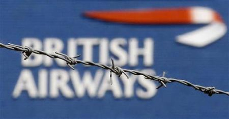 The British Airways logo is seen behind barbed wire at Heathrow Airport, west of London