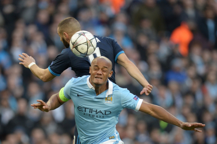 Vincent Kompany heads the ball