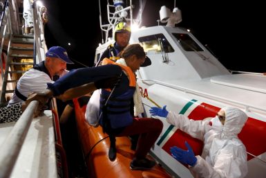 A migrant boards a coast guard vessel